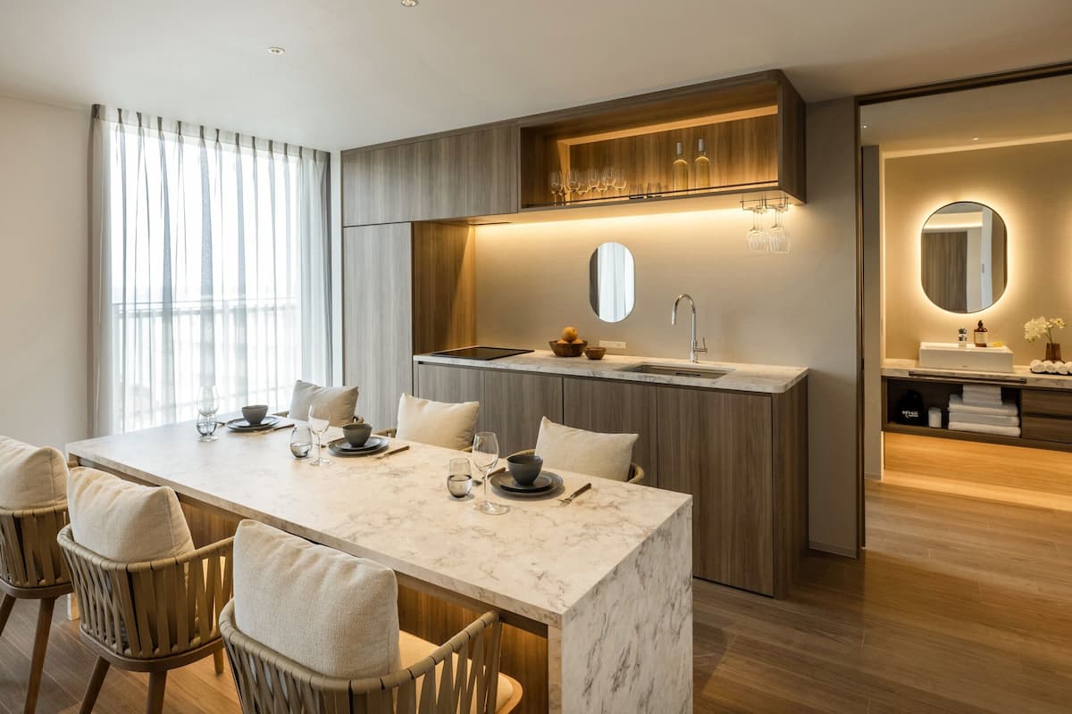 A modern kitchen with a marble countertop, wooden cabinets, and a built-in oven.