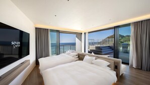 A modern hotel room with a large bed, a TV, and a balcony with a view of the sea. - seven x seven Itoshima (Fukuoka)