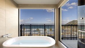 A modern bathroom with a large bathtub, a glass shower enclosure, and a balcony with a view of the ocean. - seven x seven Itoshima (Fukuoka)