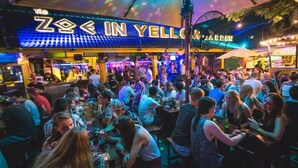 A crowded bar with neon signage reading "ZOE IN YELLOW". - Blue Dream Guesthouse (Chiang Mai)
