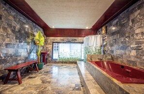 Bathroom features a bathtub, wooden bench, and a large window with a curtain.