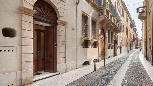 A narrow cobblestone street flanked by historic buildings with arched doorways and traditional architecture. - Verincanto Suite In old Verona Downtown (Verona)