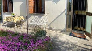 A patio with a table and chairs, a bench, and a potted plant. - VENISERELAX (Mestre)