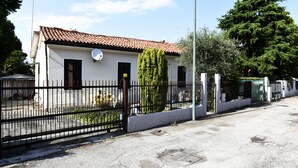 A single-story building with a tiled roof, a satellite dish, and a black metal fence. - VENISERELAX (Mestre)