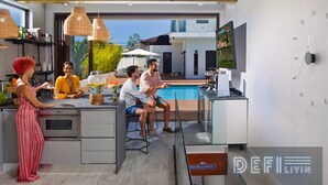 Eine moderne Küche mit einer großen Kochinsel, einem Pool und einem an der Wand befestigten Fernseher.