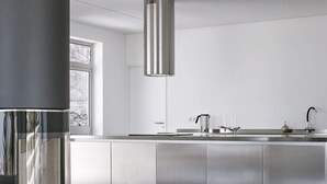 Una cocina moderna con armarios de acero inoxidable, una isla central y un ventanal que proporciona luz natural.