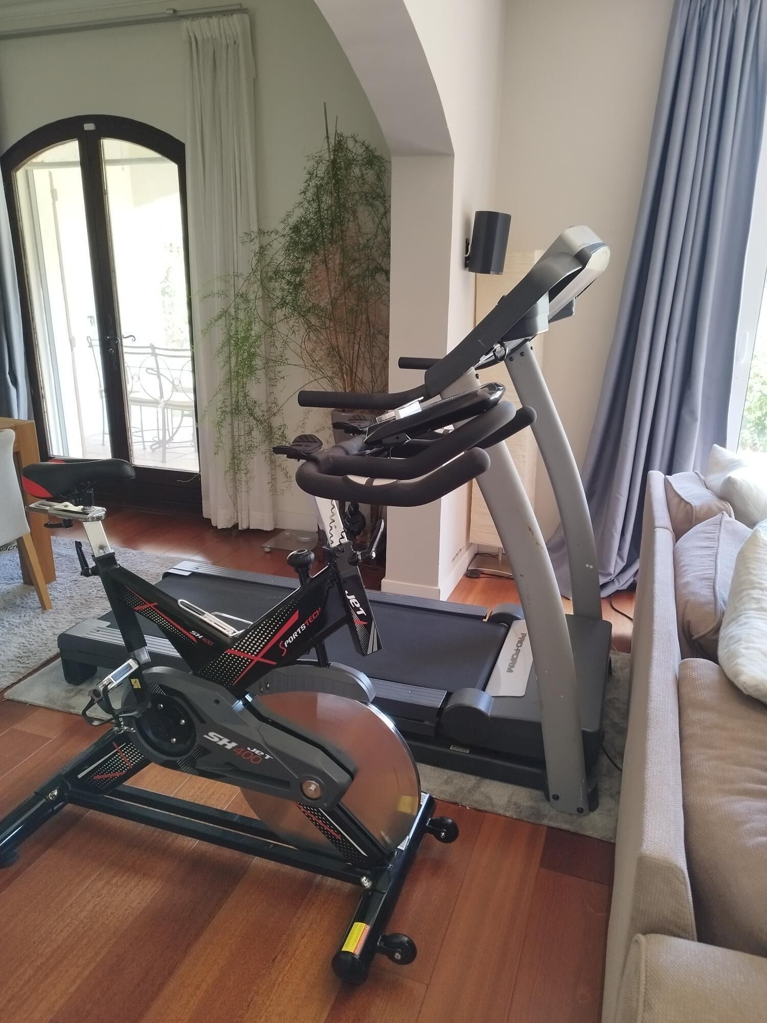 A home gym with a stationary bike, elliptical, and treadmill.