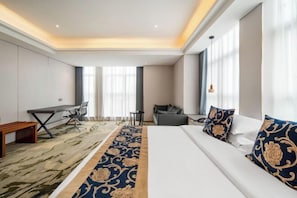 A hotel room with a large bed, a desk, a sofa, and a small table. - Kaye Hotel (Liuzhou)