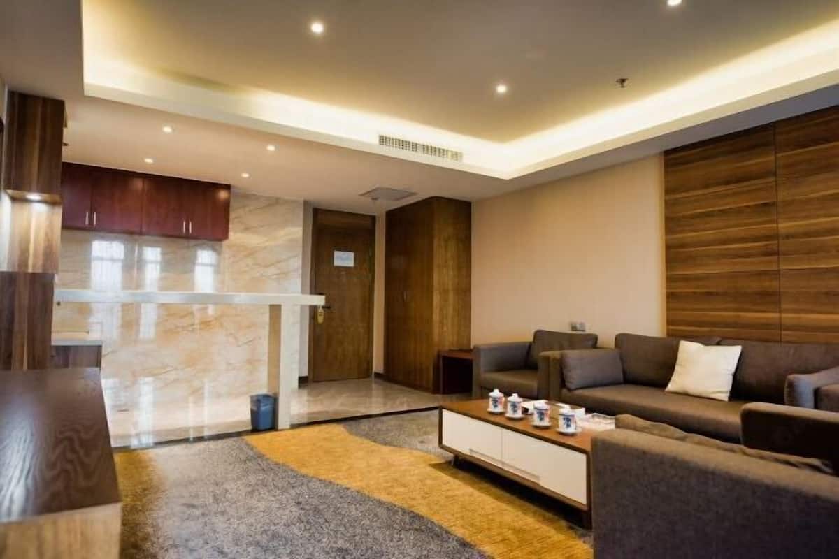 A modern living room with a sofa set, a coffee table, and a marble accent wall.