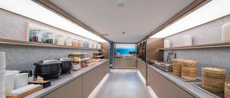 A modern kitchen with a central island, stainless steel appliances, and neatly arranged food containers.