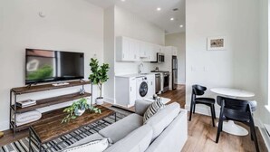 A modern apartment with a living room, kitchen, and dining area. - Sosuite | 1BR Apt w W/D, Gym, Lounge, Park View (Philadelphia)