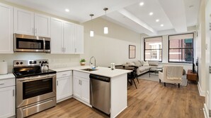 A modern kitchen with white cabinetry, stainless steel appliances, and a central island. - Sosuite | 2BR Apt w W/D, Gym, Lounge (Philadelphia)