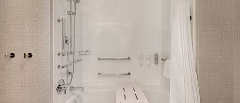 A modern bathroom with a bathtub, shower, and toilet.