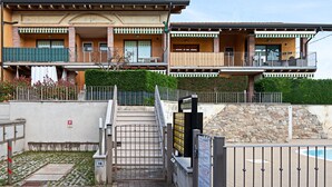 A multi-story residential building with balconies, a gated entrance, and a swimming pool. - Regarda - "Costa del Sole" with swimming pool and terrace (Lazise)