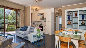 Ein modernes Wohnzimmer mit Sofa, Couchtisch und Essbereich mit Stühlen und Tisch.