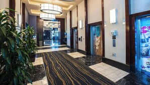 Eine Hotelhalle mit Marmorboden, moderner Beleuchtung und einer Rezeption.