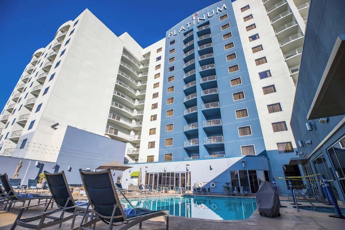 Un hotel con zona de piscina, que incluye sillas de descanso y una piscina.