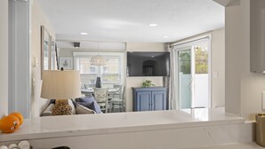 A modern kitchen with a marble countertop, a dining area with a table and chairs, and a blue cabinet. - Downtown Luxury Villa on the Plymouth Waterfront (Plymouth)