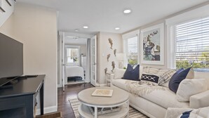 A modern living room with a sofa, coffee table, and TV stand. - Downtown Luxury Villa on the Plymouth Waterfront (Plymouth)