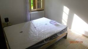 Una habitación con cama, ventana y radiador.