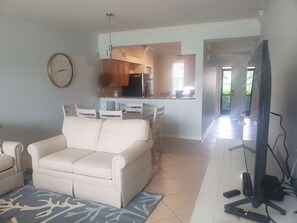 Relax in this stylish living room with a sofa, dining area, and large flat-screen TV.