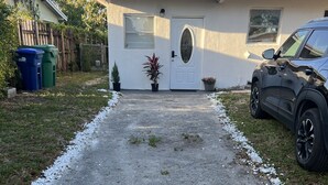 A driveway leading to a house with a front door, a garage, and a parked car. - Miami Gardens Comfort Suite by Hard Rock Stadium (Miami Gardens)