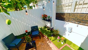 A patio with a seating area, a small table, and potted plants. - Miami Gardens Comfort Suite by Hard Rock Stadium (Miami Gardens)