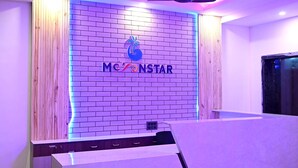 A reception area with a brick wall and a logo that reads "MCNSTAR". - Moon Star Beach Resort (Kanthi)
