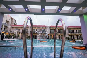 Una piscina interior con vistas a un edificio con balcones y techo rojo.