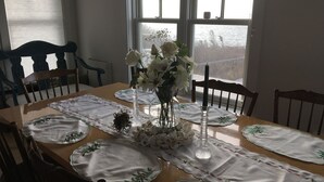 Une table à manger dressée avec des nappes blanches et agrémentée de compositions florales.