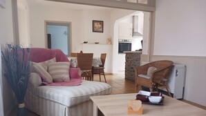 A living room with a sofa, a coffee table, and a dining area with chairs.