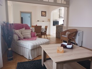 Relax in this stylish living area with a comfortable sofa, coffee table, and wicker chair.