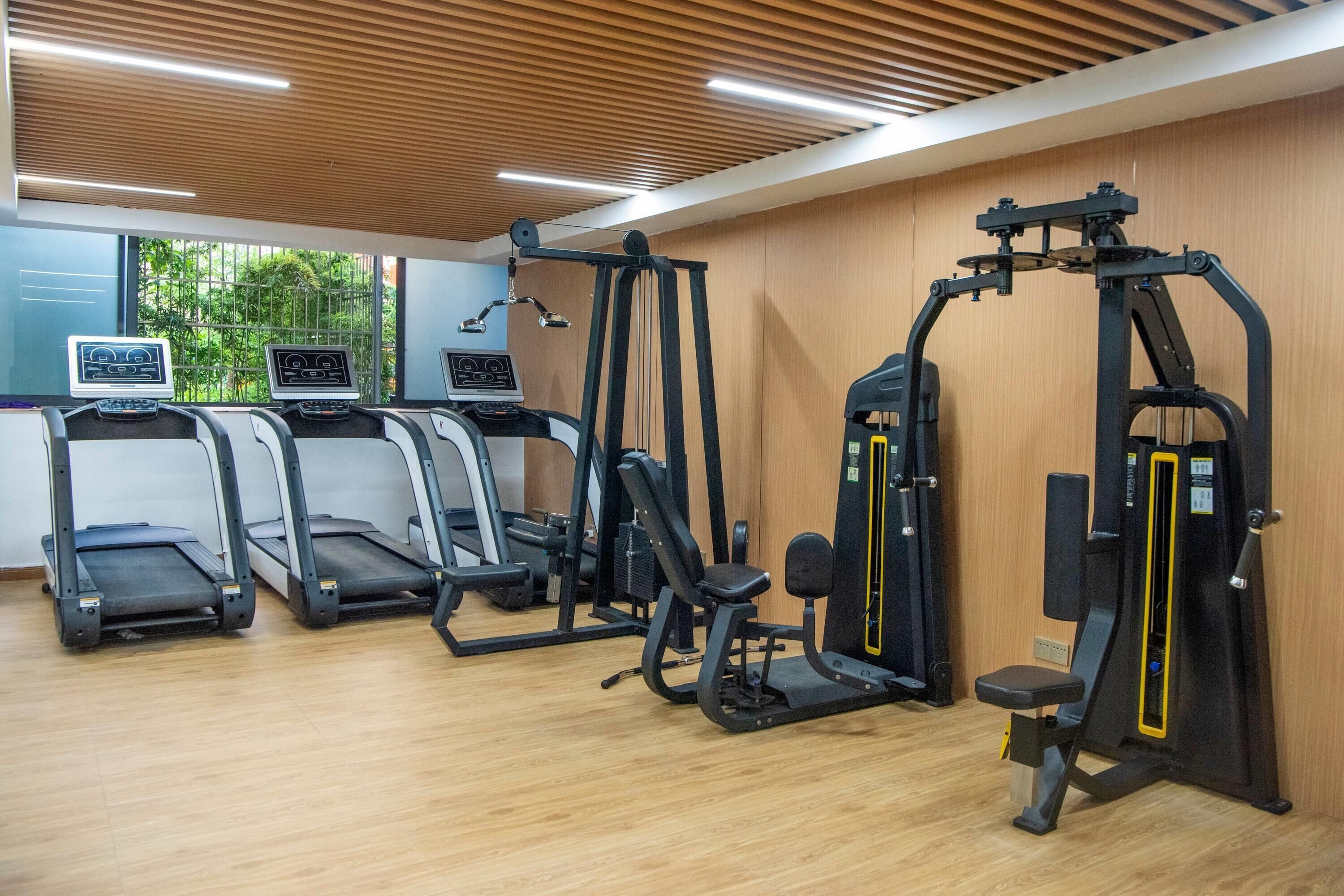 A gym with treadmills, weight machines, and a mirror.