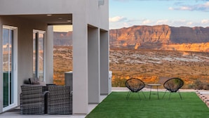 A modern outdoor patio with wicker furniture and a view of a desert landscape. - Pueblo en Powell - Hot Tub, Game Room, Lake Views (Page)