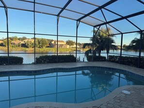 Une piscine avec vue sur un lac et des maisons en arrière-plan.