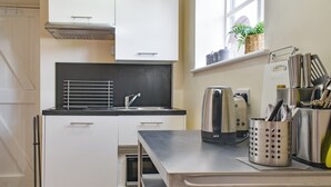 A compact kitchen with a sink, a kettle, and a utensil holder. - 1 bedroom accommodation in Wellow, near Yarmouth (Wellow, near Yarmouth)