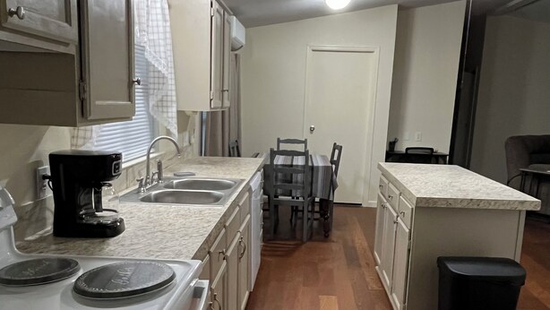 A kitchen with a stove, sink, and dining area. - Relax after a Day on the Lake! (Hulbert)