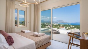 Une chambre moderne dotée d’un grand lit, d’un bureau et d’un balcon offrant une vue panoramique.