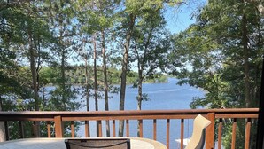 A wooden deck with a table and chairs overlooking a lake. - Escape to Paradise: Your dream vacation awaits in our stunning lakefront rental! (Tomahawk)