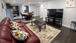 A modern living room with a leather sofa, a coffee table, and a flat-screen TV.