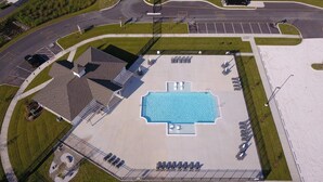 An aerial view of a hotel with a swimming pool, parking lot, and a fenced area with lounge chairs. - Condo on Rehoboth Bay close to beaches and boating (Lewes)