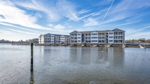 A waterfront apartment complex with multiple buildings, docks, and a clear sky. - Condo on Rehoboth Bay close to beaches and boating (Lewes)