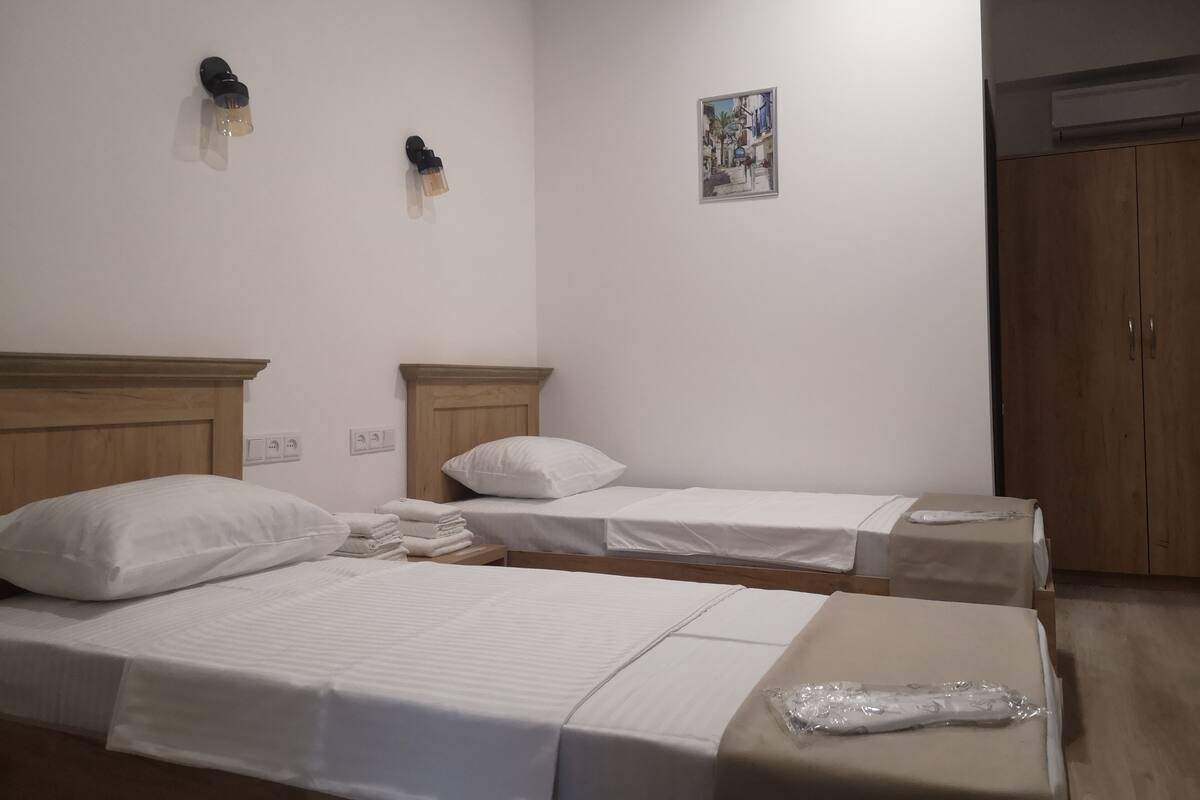 Twin kamer | Een kluis op de kamer, een bureau, een laptopwerkplek