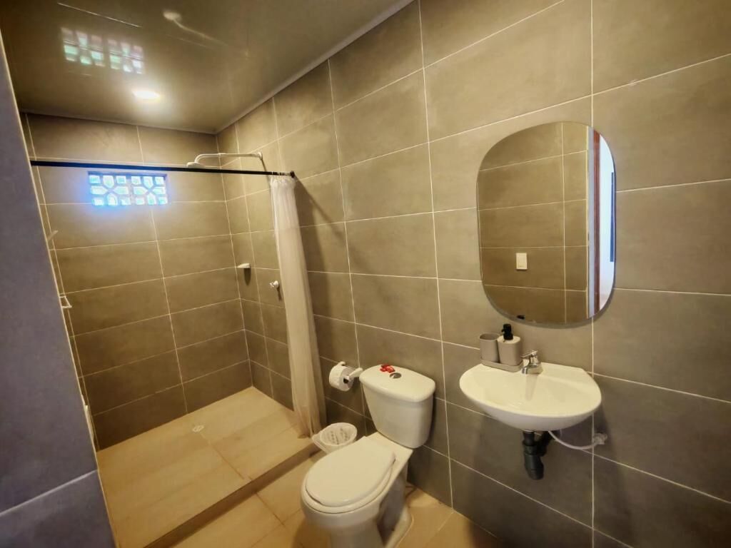 A bathroom with a toilet, sink, and shower.