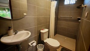 Une salle de bain équipée d’un lavabo, de toilettes et d’une douche.