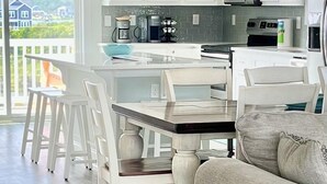 Una cocina moderna con armarios blancos, una isla central e iluminación colgante.