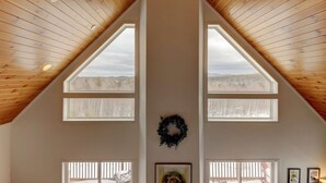 A room with a high, sloped ceiling and large windows. - Tranquil mountain view home near downtown North Conway
Mountain Views. Cable TV. (Madison)