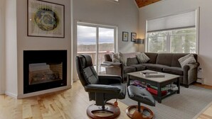A spacious living room with a fireplace, a leather chair, a sofa, and a coffee table. - Tranquil mountain view home near downtown North Conway
Mountain Views. Cable TV. (Madison)