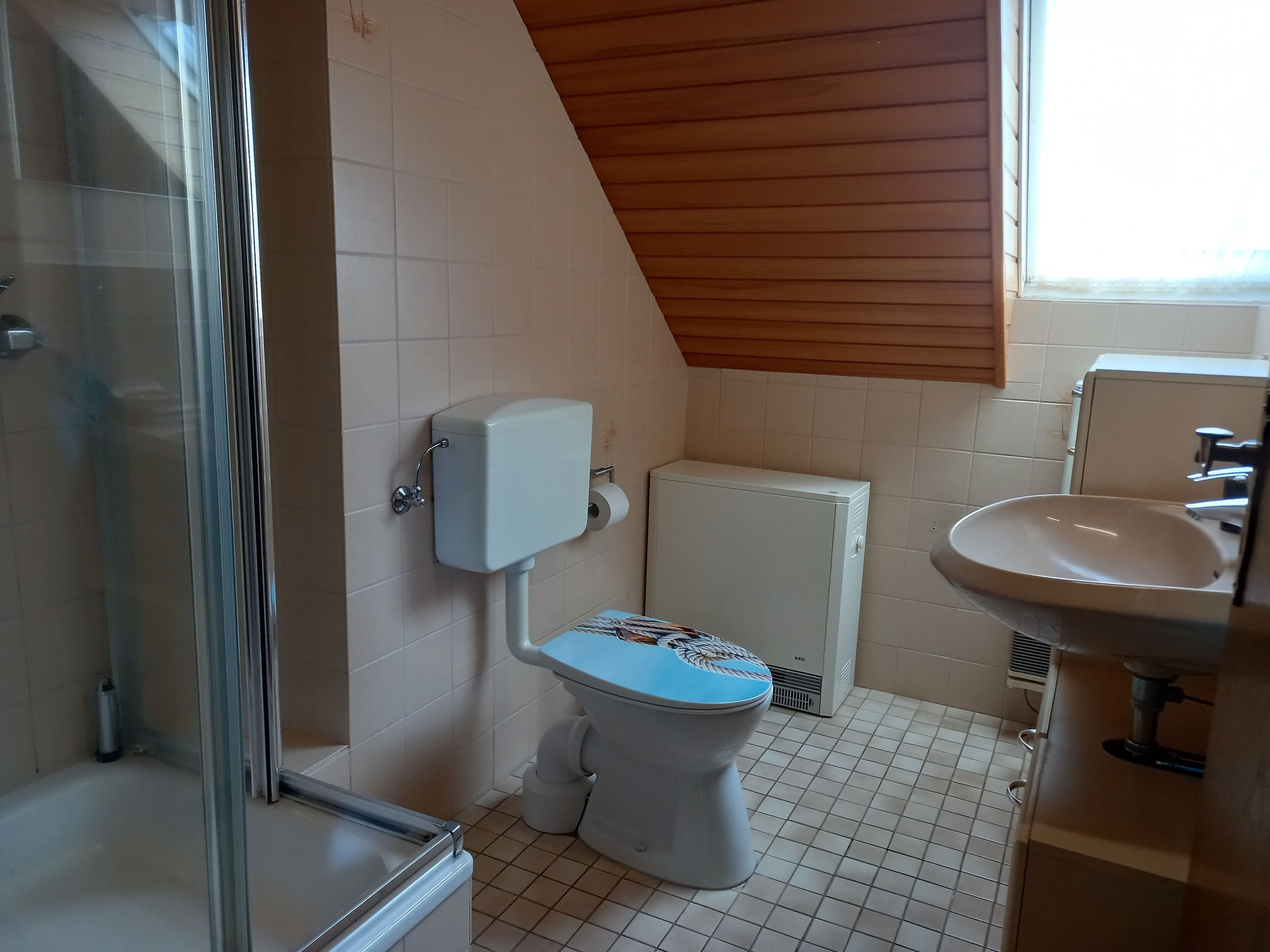 Une salle de bain comprenant des toilettes, un lavabo et un espace douche.