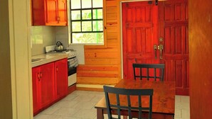 Una cocina con armarios de madera, una ventana y una mesa de comedor con sillas.